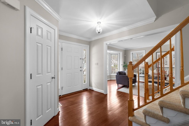 foyer entrance featuring dark wood-style floors, stairway, crown molding, and baseboards