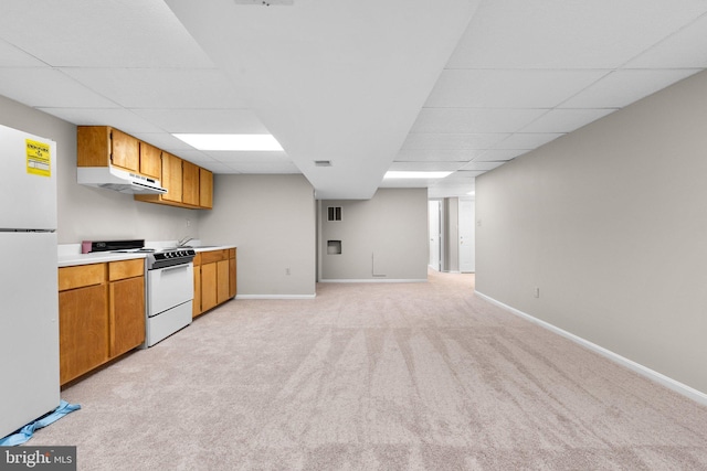 kitchen featuring under cabinet range hood, a drop ceiling, white appliances, and light carpet