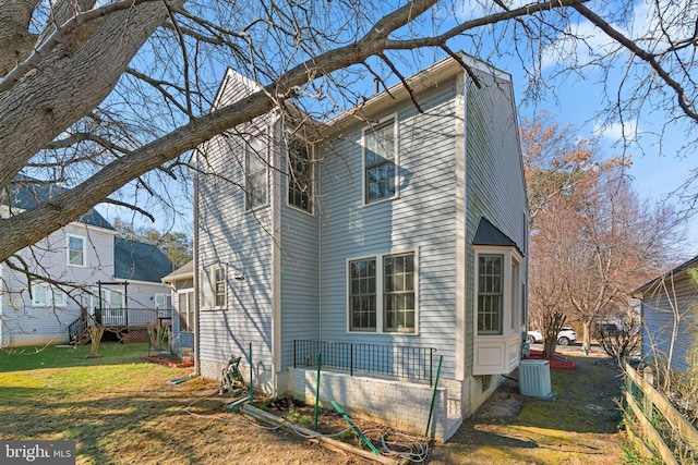 view of side of home featuring central air condition unit and a lawn