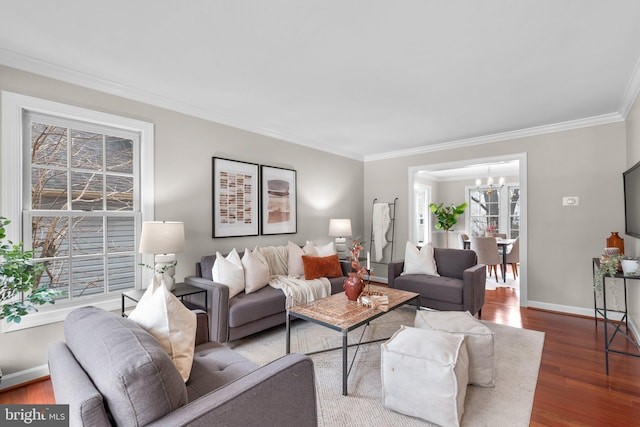 living room with a chandelier, ornamental molding, baseboards, and wood finished floors