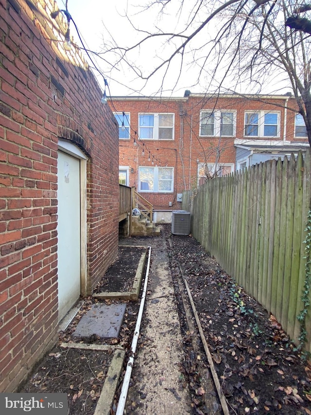 view of yard featuring cooling unit and fence