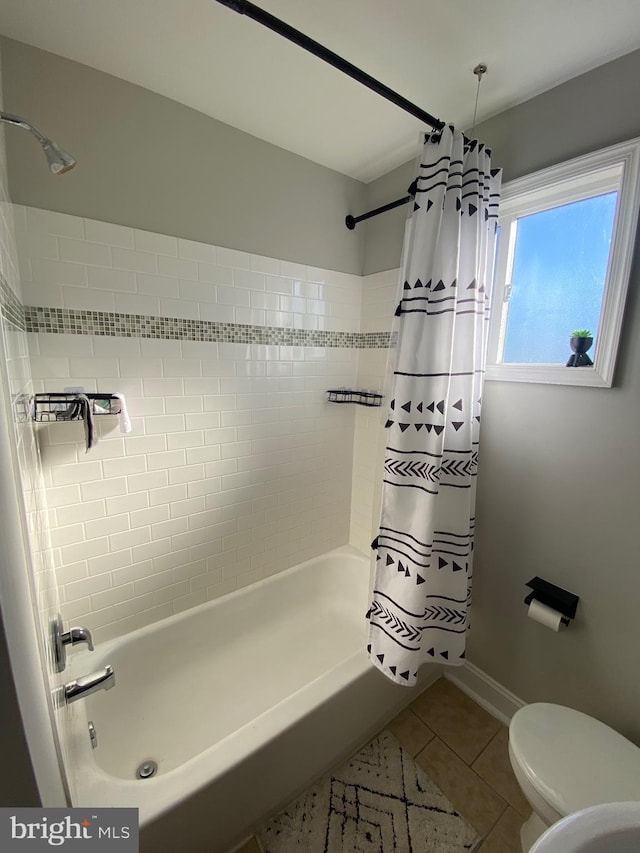 full bath featuring tile patterned flooring, baseboards, shower / tub combo with curtain, and toilet