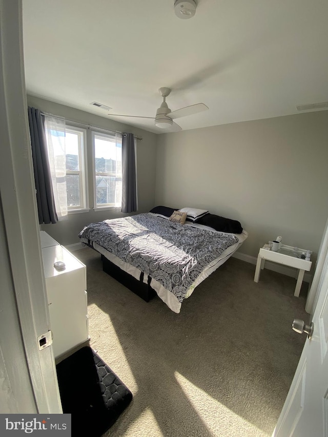 bedroom featuring baseboards, carpet, visible vents, and a ceiling fan