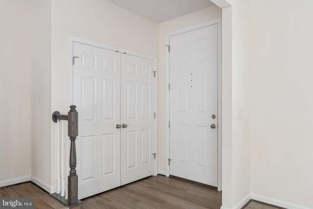 doorway featuring baseboards and wood finished floors