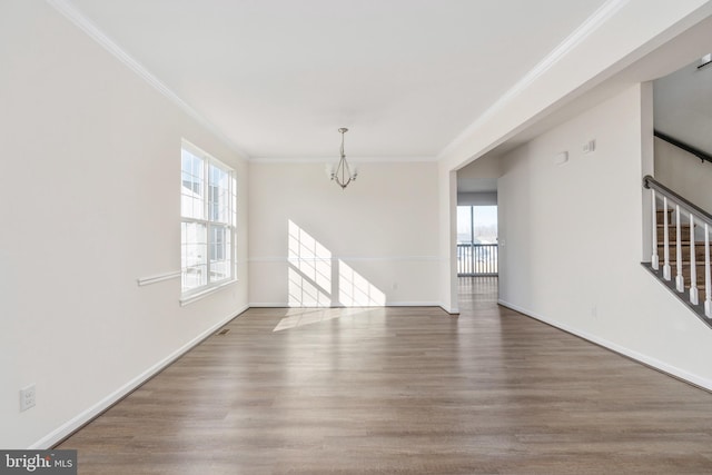 empty room with baseboards, stairway, ornamental molding, wood finished floors, and a notable chandelier