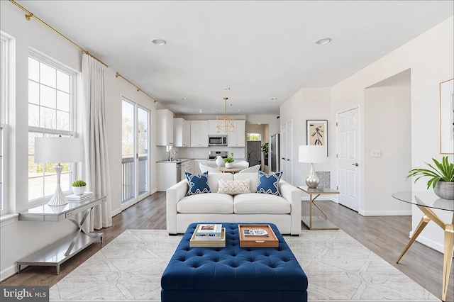 living area with light wood-type flooring, baseboards, and recessed lighting