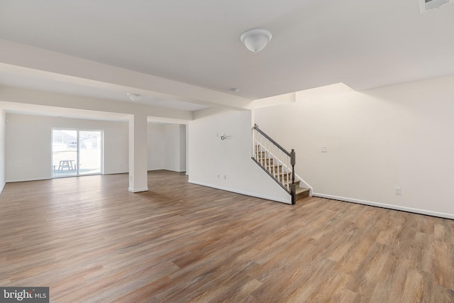 interior space featuring visible vents, stairs, baseboards, and wood finished floors