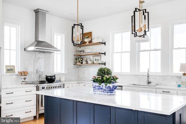 kitchen featuring light stone counters, electric range, a sink, wall chimney range hood, and a center island