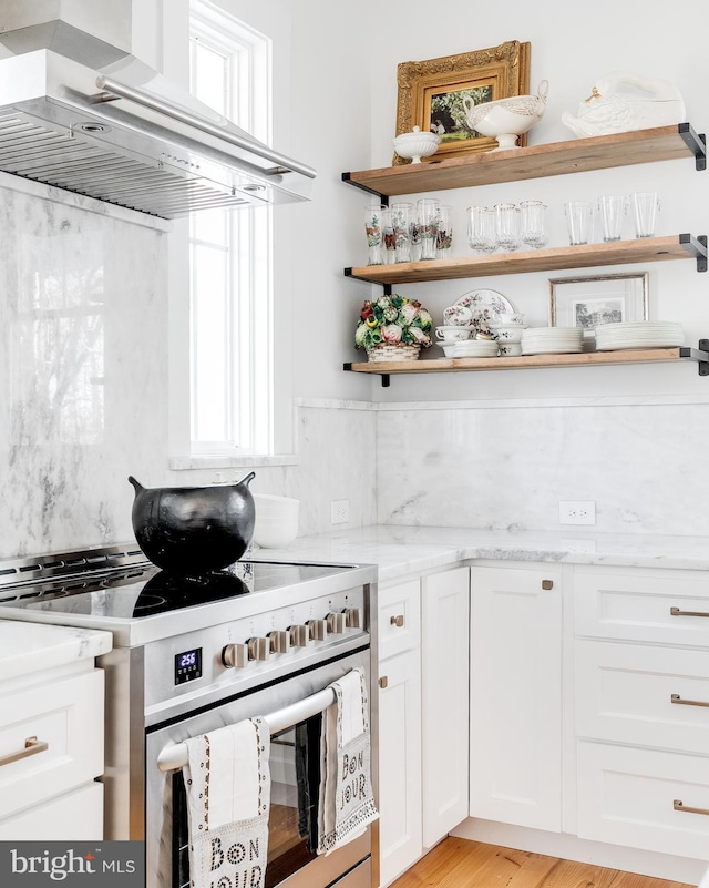 kitchen with open shelves, electric range, decorative backsplash, and range hood