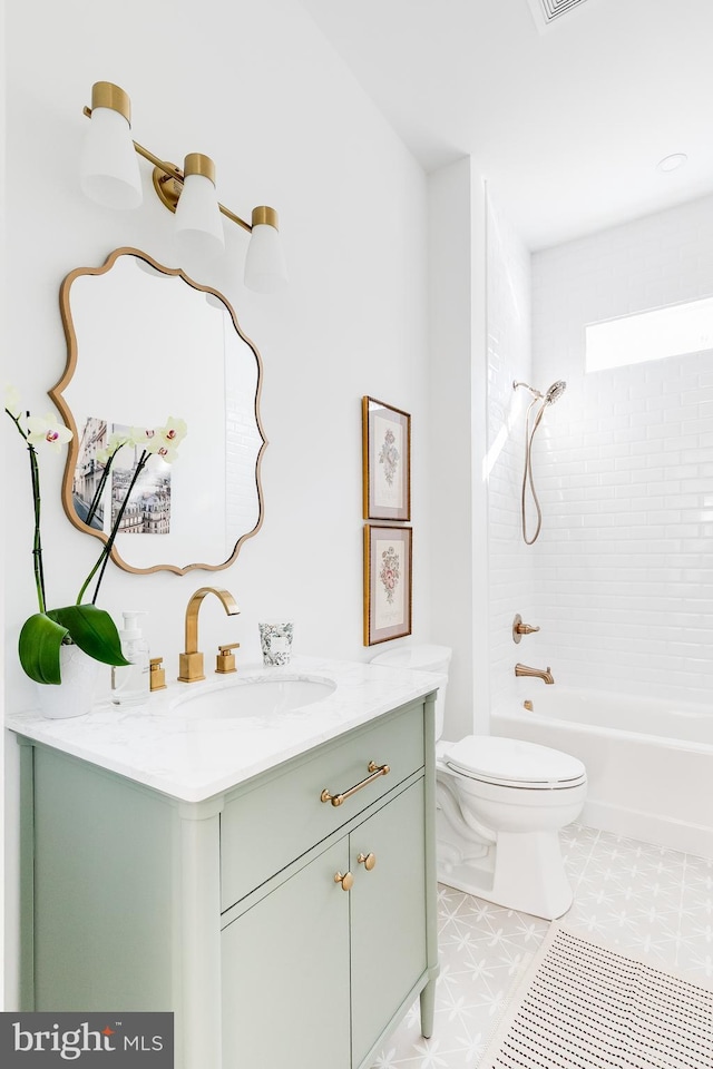 full bath with tub / shower combination, vanity, toilet, and tile patterned floors