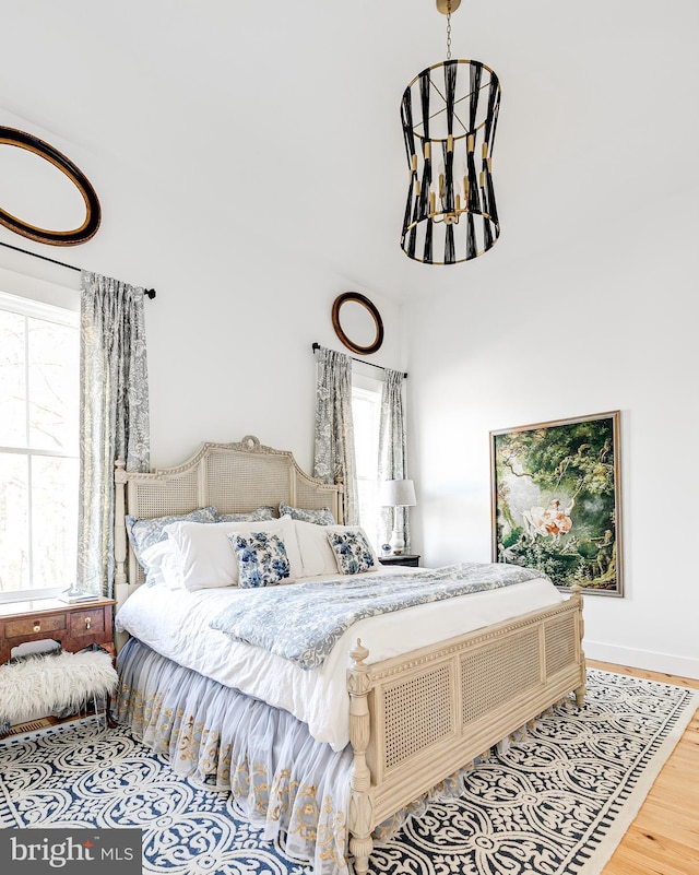 bedroom featuring a notable chandelier and wood finished floors