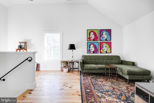 living room featuring lofted ceiling and light wood-type flooring