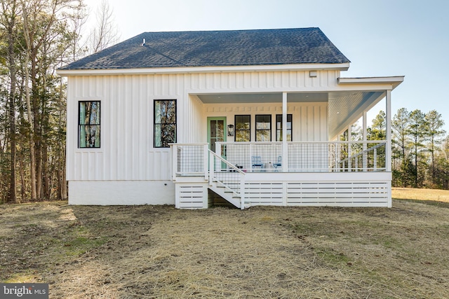 view of front of property with board and batten siding, covered porch, and roof with shingles