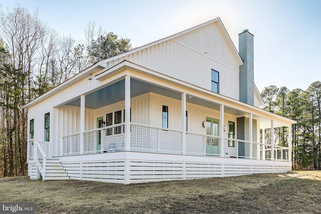 view of front of house featuring covered porch and a chimney