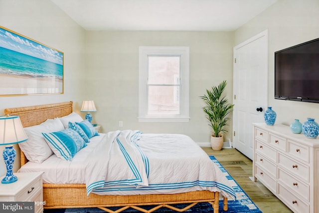 bedroom featuring light wood-style flooring and baseboards