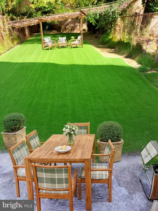 view of yard featuring a patio area, fence, and outdoor dining area