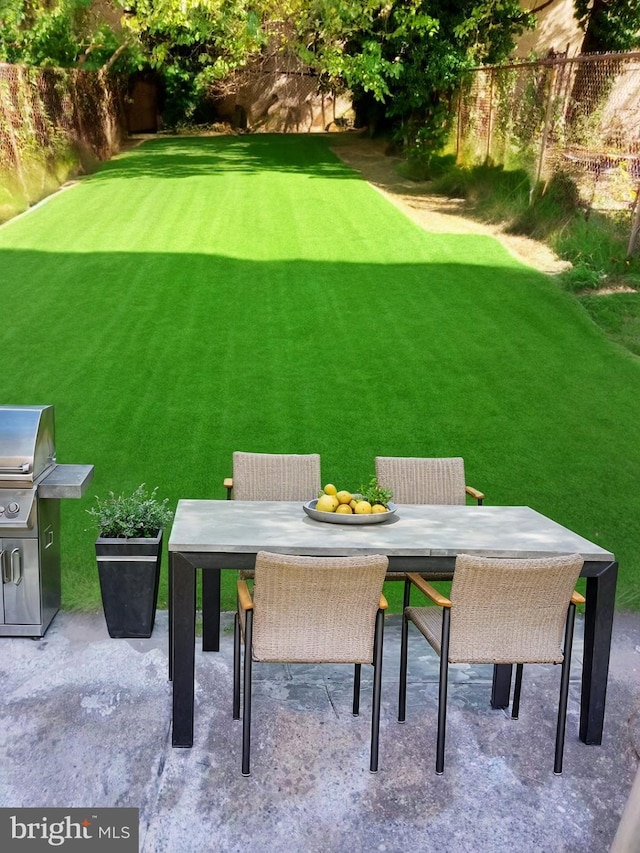 view of yard featuring fence, a patio, and outdoor dining space