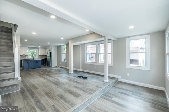 unfurnished living room featuring wood finished floors and baseboards