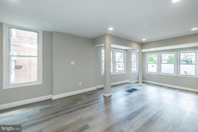 interior space featuring visible vents, baseboards, wood finished floors, and recessed lighting