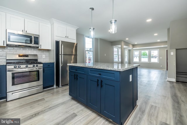 kitchen with stainless steel appliances, white cabinetry, blue cabinetry, backsplash, and light wood finished floors