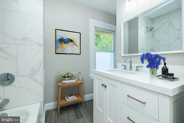 bathroom with tub / shower combination, wood finished floors, vanity, and baseboards