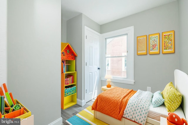 bedroom featuring wood finished floors and baseboards