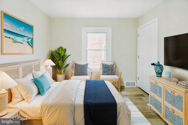 bedroom featuring visible vents, baseboards, and wood finished floors