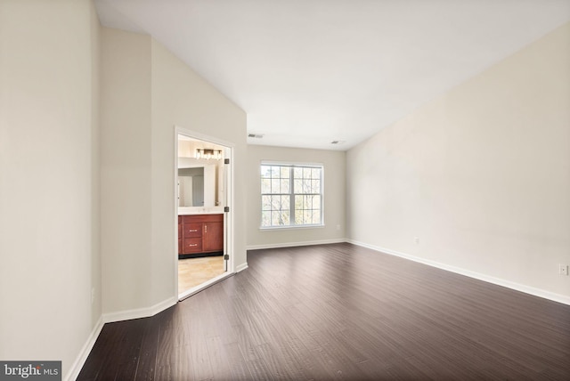 unfurnished living room featuring dark wood-style floors, visible vents, and baseboards