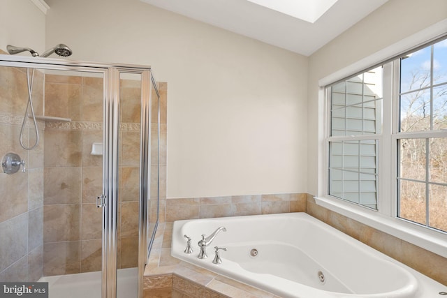 full bath featuring a stall shower, a skylight, and a jetted tub