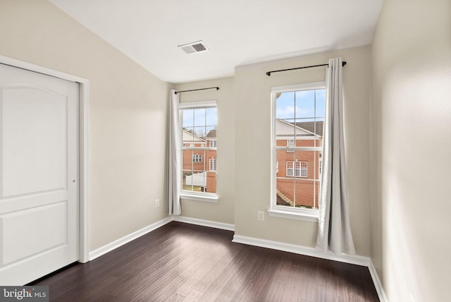 interior space featuring dark wood-type flooring, visible vents, and baseboards