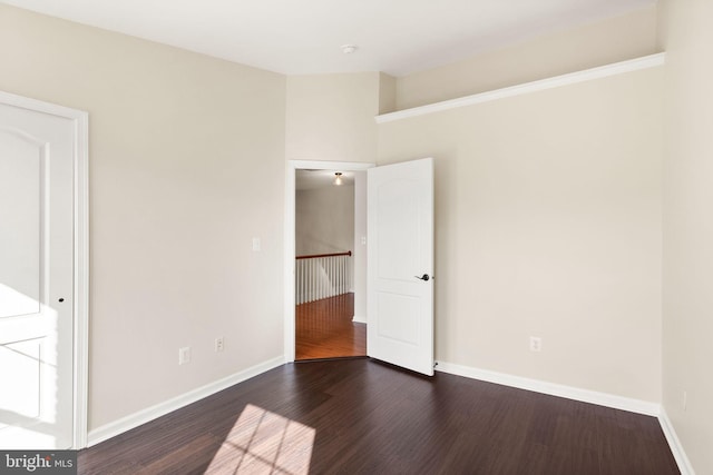 unfurnished bedroom featuring baseboards and dark wood-style flooring