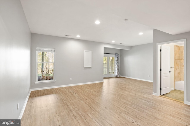 unfurnished room with baseboards, light wood finished floors, visible vents, and recessed lighting