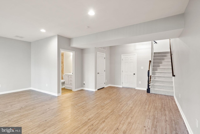 basement with recessed lighting, baseboards, stairway, and light wood finished floors