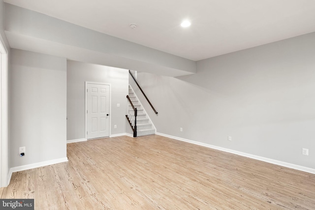 unfurnished room featuring stairs, recessed lighting, baseboards, and light wood-style floors