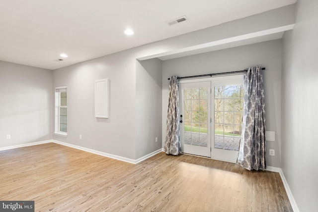 unfurnished room with light wood-type flooring, baseboards, visible vents, and recessed lighting