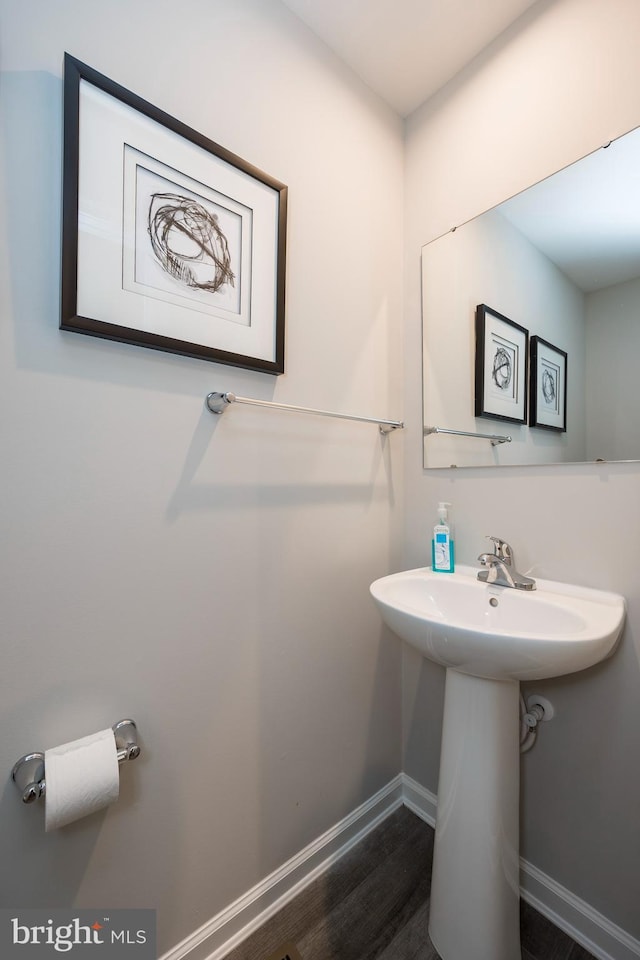 bathroom with a sink, baseboards, and wood finished floors