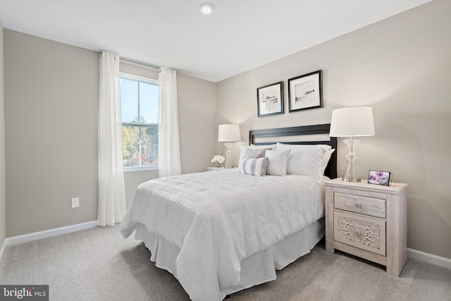 bedroom featuring light carpet and baseboards