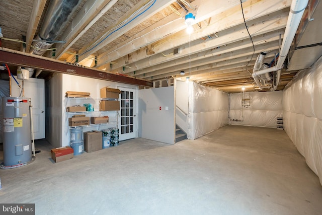 unfinished below grade area featuring water heater and stairway