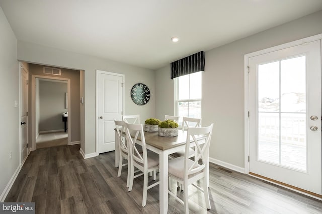 dining area with visible vents, baseboards, and wood finished floors