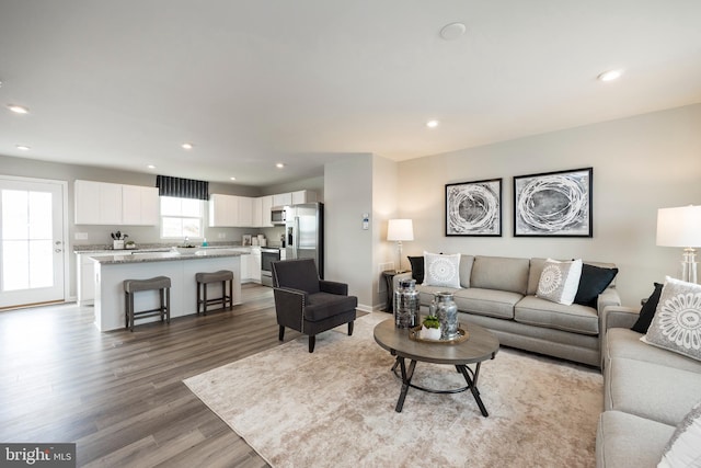 living room with baseboards, wood finished floors, and recessed lighting