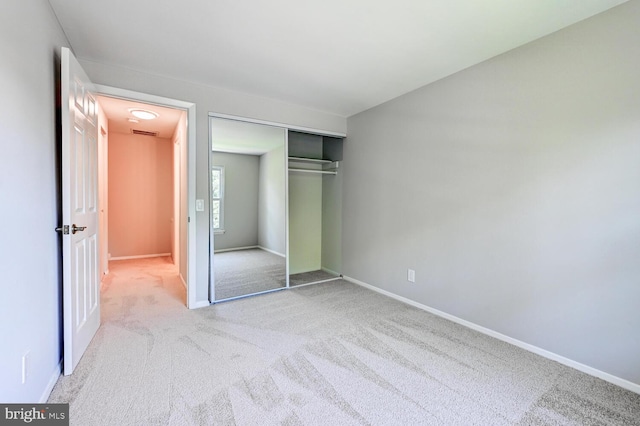 unfurnished bedroom with carpet floors, baseboards, a closet, and visible vents