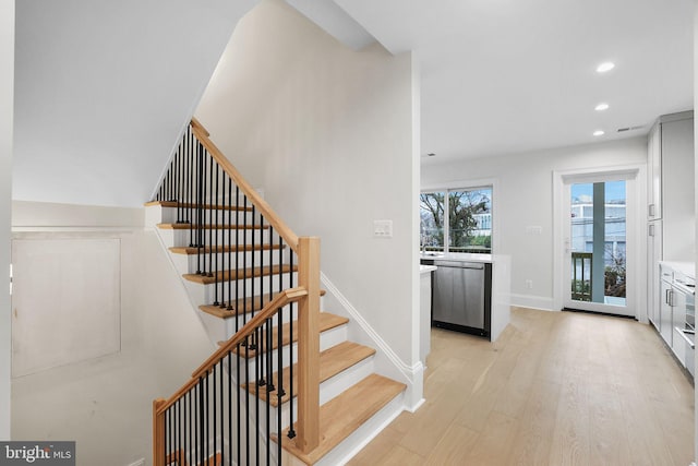 stairway with recessed lighting, baseboards, and wood finished floors