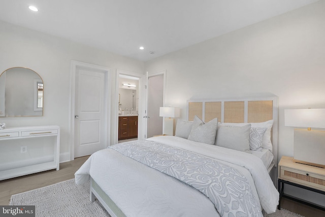 bedroom with recessed lighting, connected bathroom, and light wood-style floors