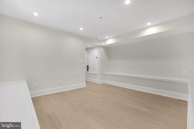 spare room with recessed lighting, baseboards, and light wood finished floors