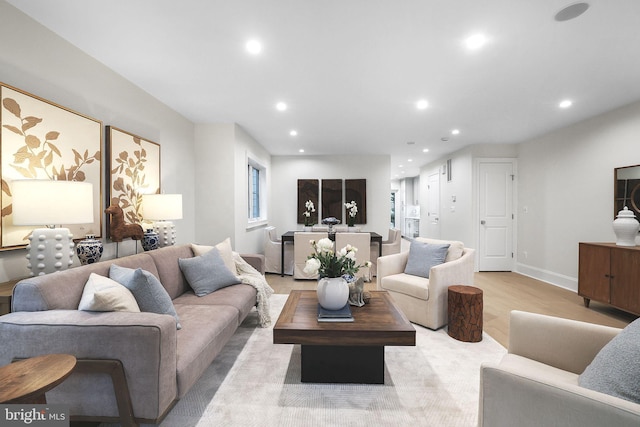 living room with recessed lighting, baseboards, and light wood-style flooring