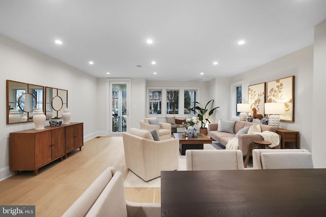 living area featuring recessed lighting, baseboards, and light wood finished floors