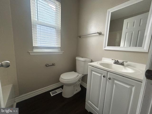 full bath featuring baseboards, visible vents, toilet, a bathing tub, and vanity