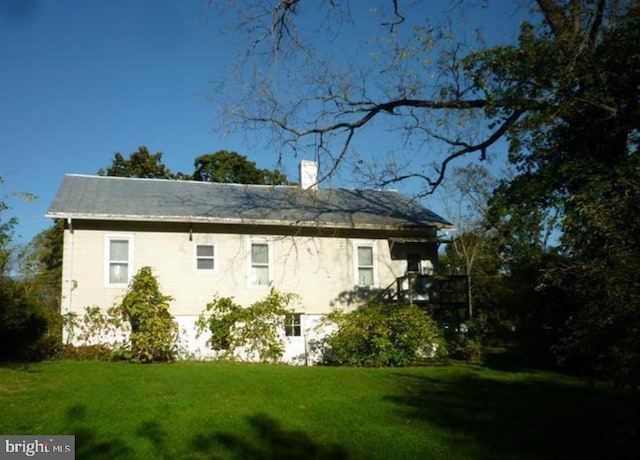 view of side of home featuring a yard and a chimney