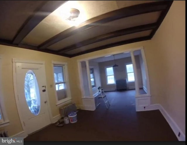 entrance foyer with baseboards, decorative columns, and radiator heating unit