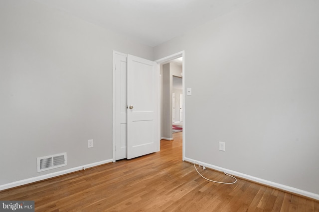 unfurnished bedroom with visible vents, light wood-style flooring, and baseboards